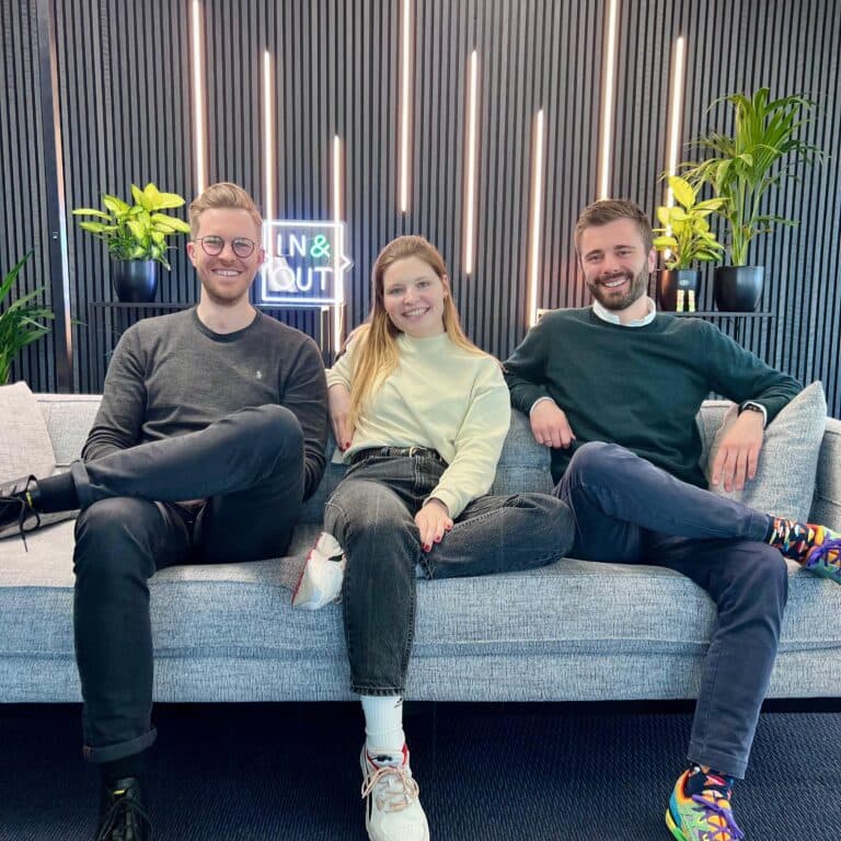 Team auf dem Sofa vor dem In&Out Sign