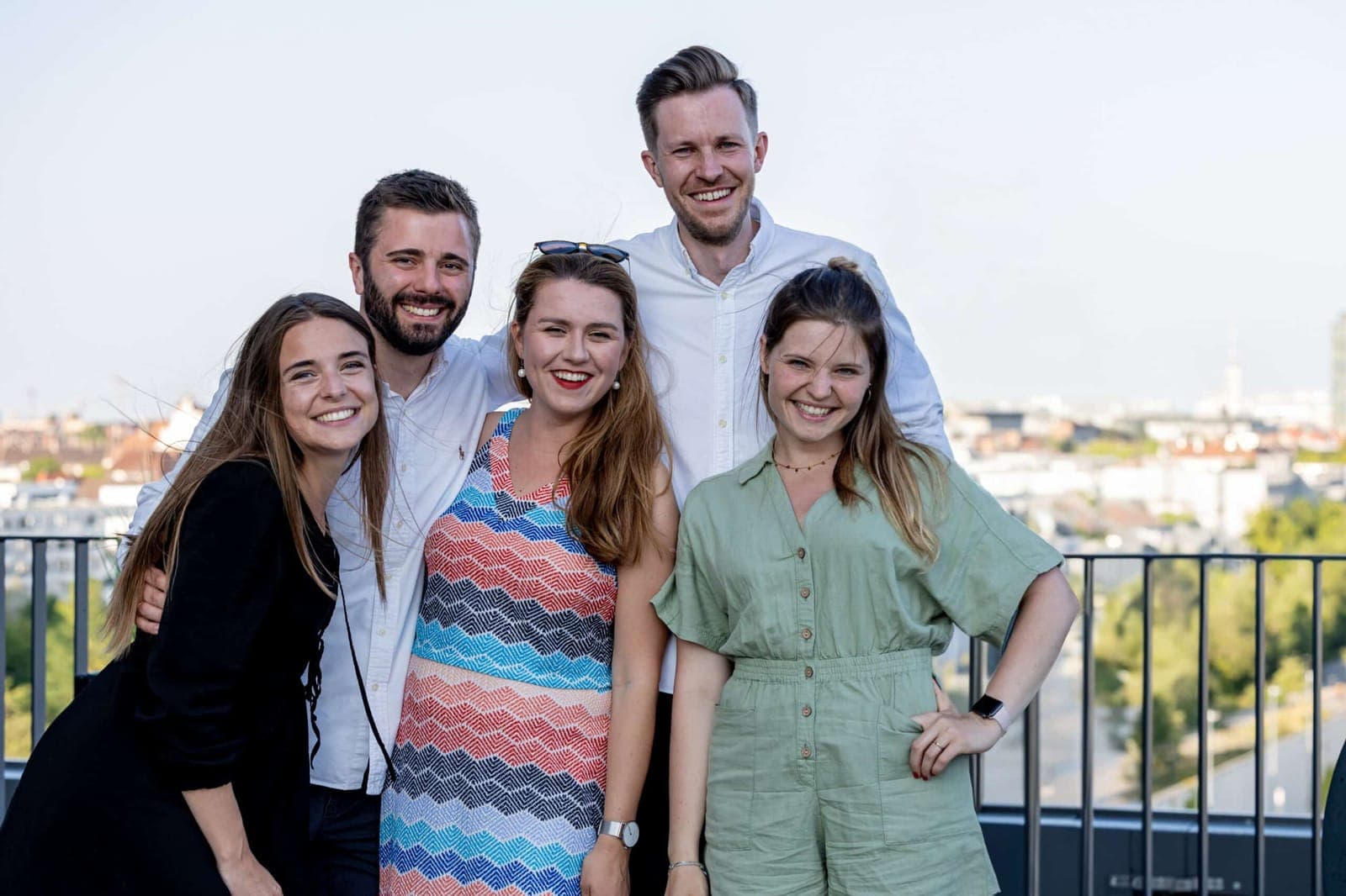 Das In&Out-Team auf der Dachterrasse mit Blick über München